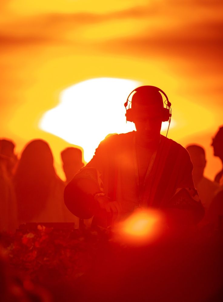 DJ silhouetted against a sunset